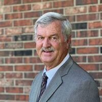 Rod Reid standing in front of a brick wall.