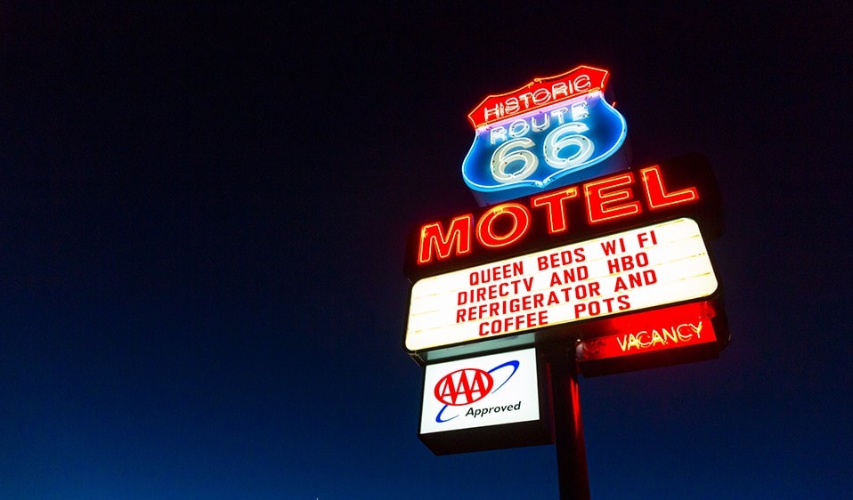 A motel sign on a pole.