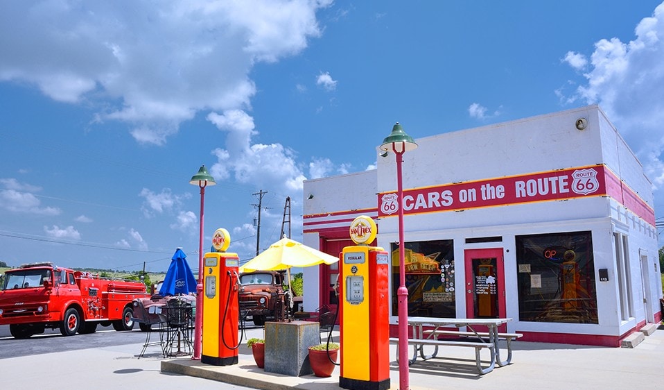 A gas station with a fire truck in front of it.